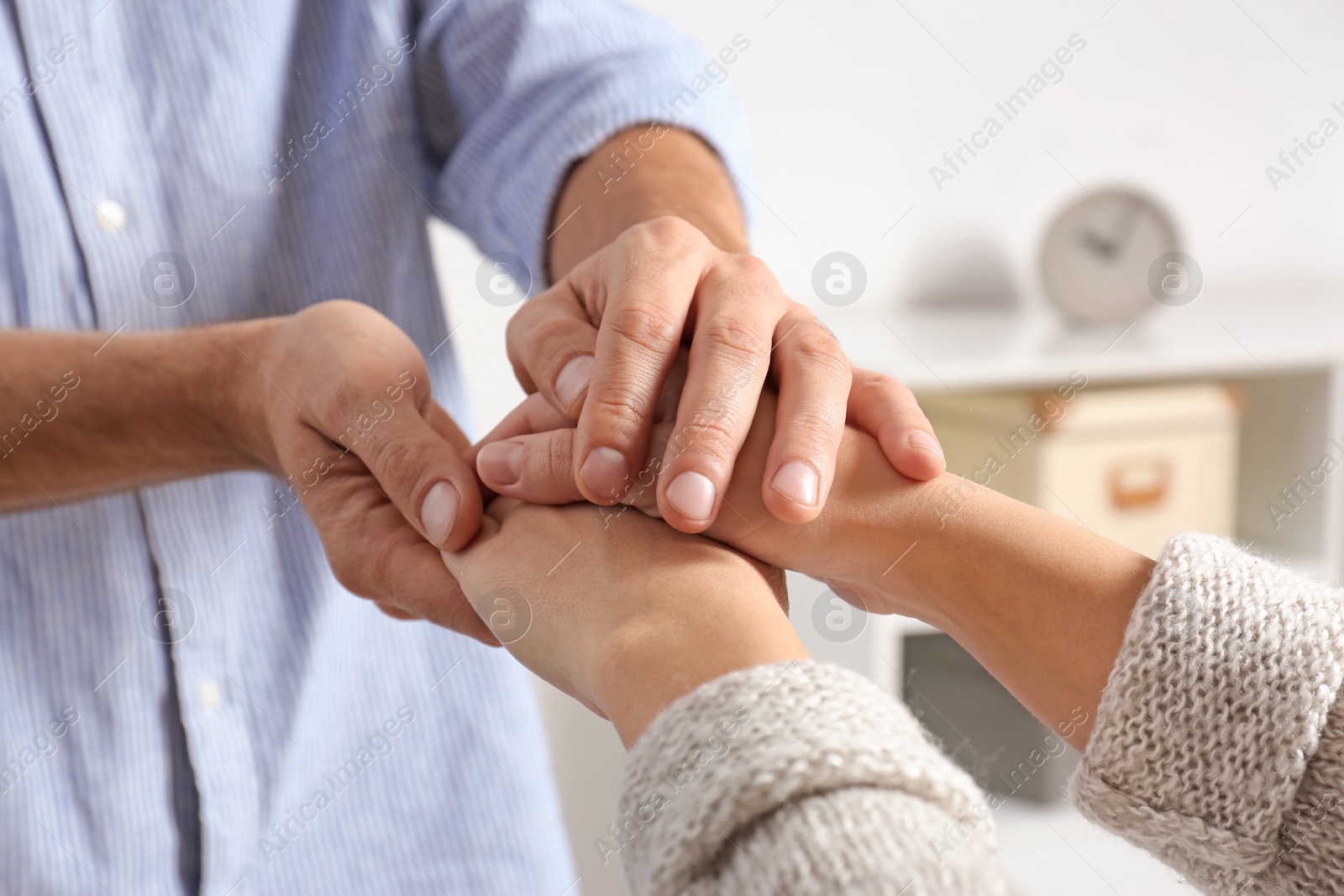 Photo of Man comforting woman on blurred background, closeup of hands. Help and support concept