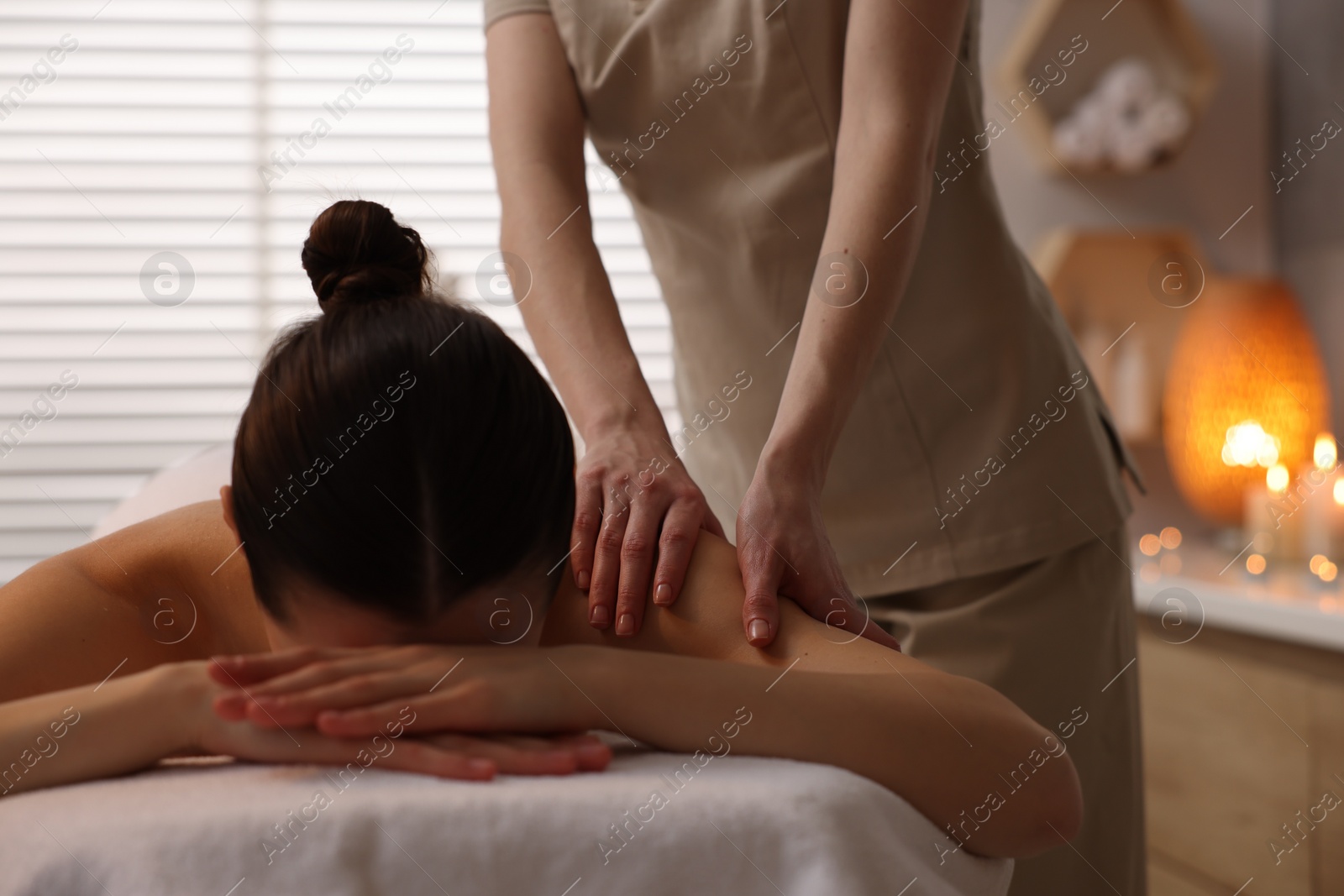 Photo of Woman receiving massage on couch in spa salon