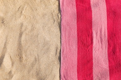 Photo of Soft pink beach towel on sand, top view. Space for text