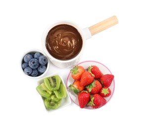 Photo of Fondue pot with melted chocolate and fresh berries isolated on white, top view