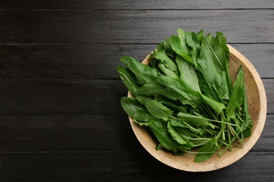 Photo of Fresh green sorrel leaves on black wooden table, top view. Space for text