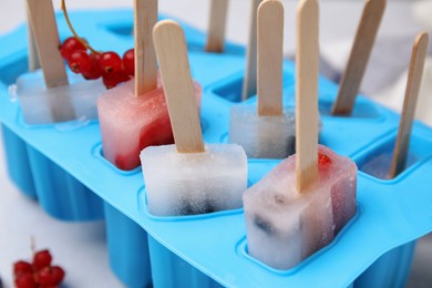 Photo of Mold with fruit and berry ice pops, closeup