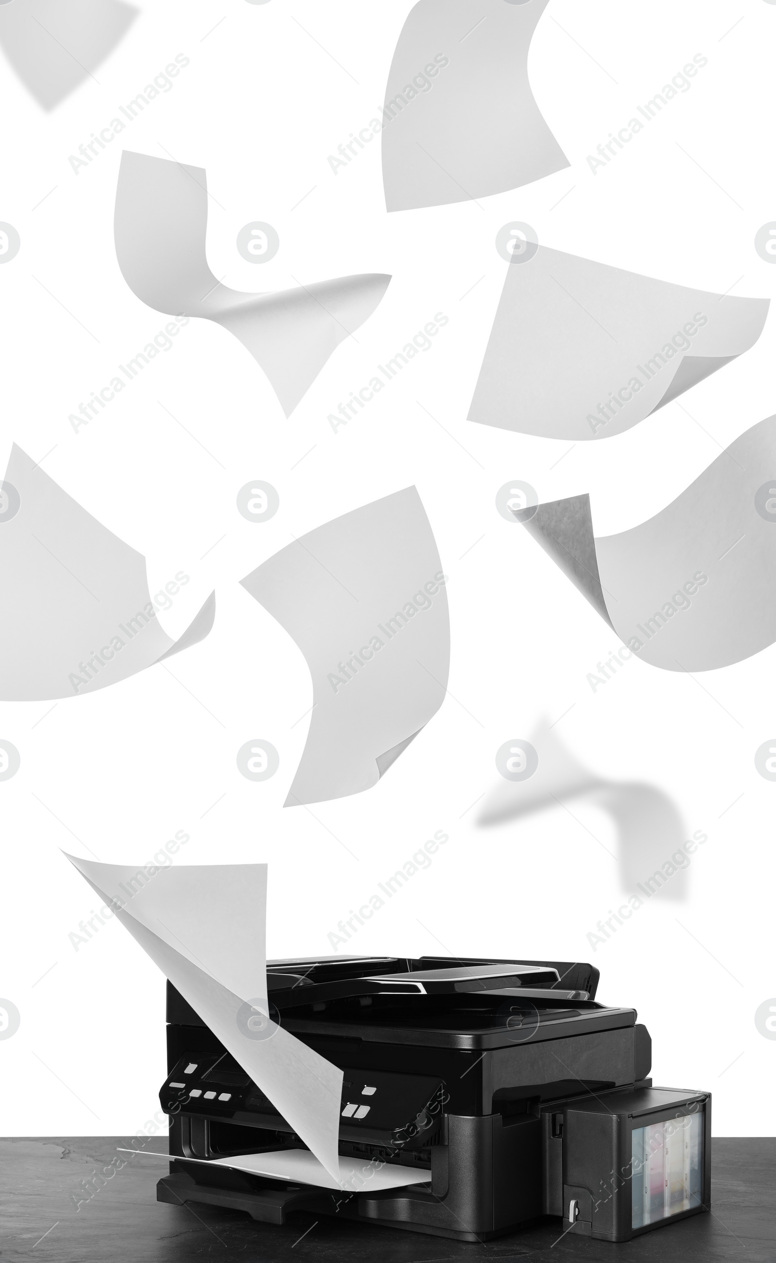 Image of Modern multifunction printer on table and flying sheets of paper against white background