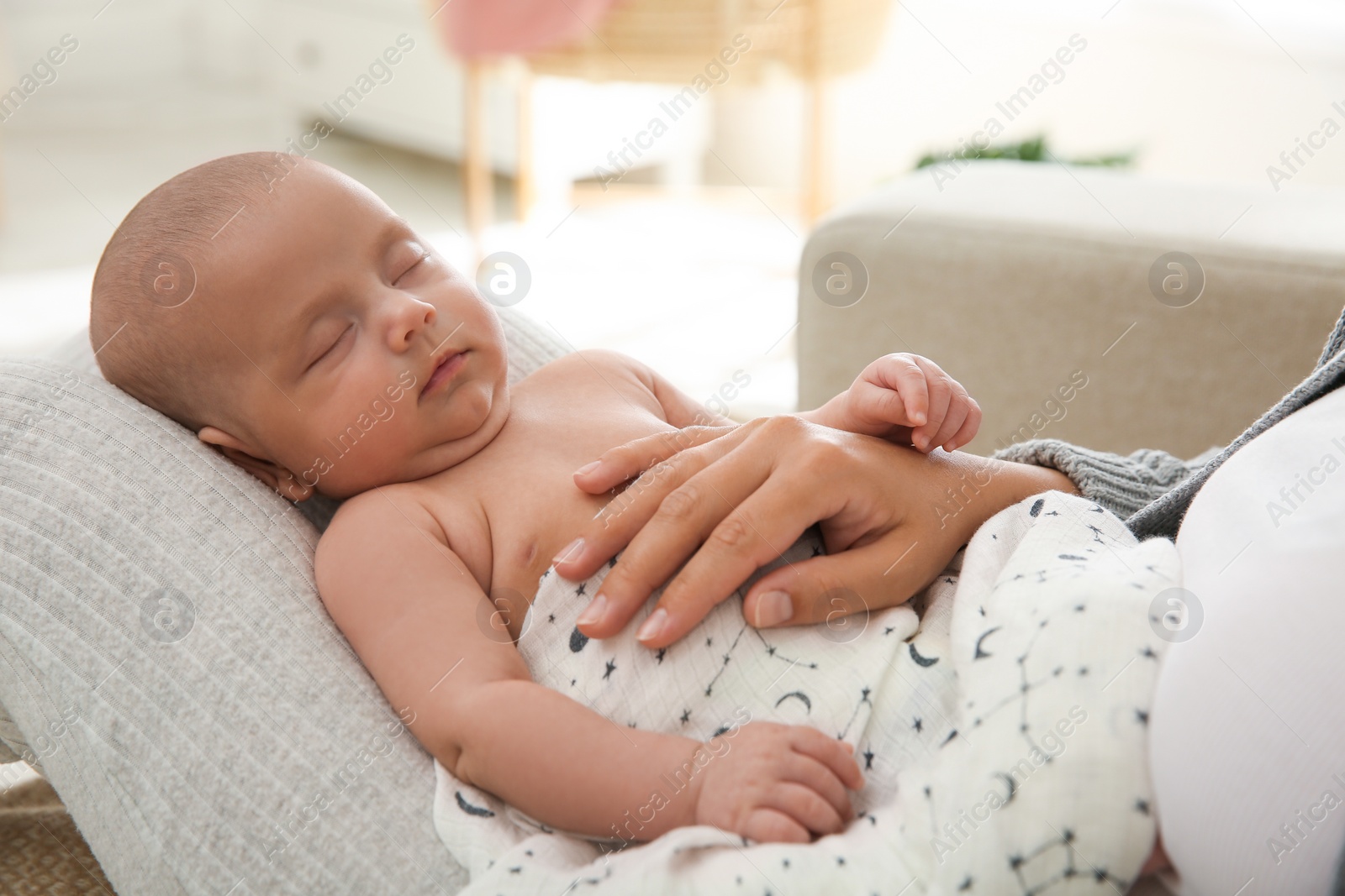 Photo of Mother holding her sleeping baby at home, closeup