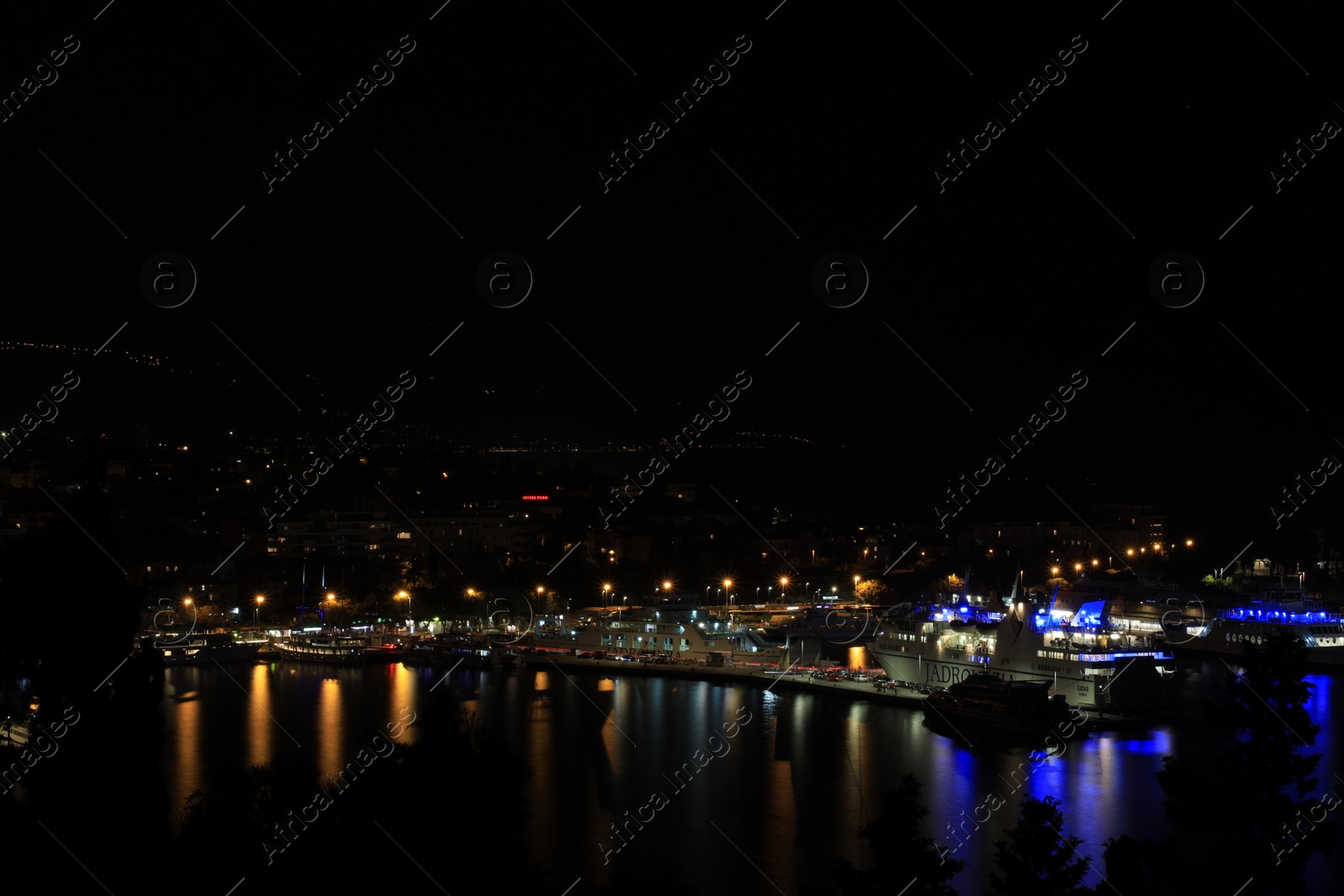 Photo of SPLIT, CROATIA - OCTOBER 08, 2023: Beautiful view of illuminated city with port and buildings at night