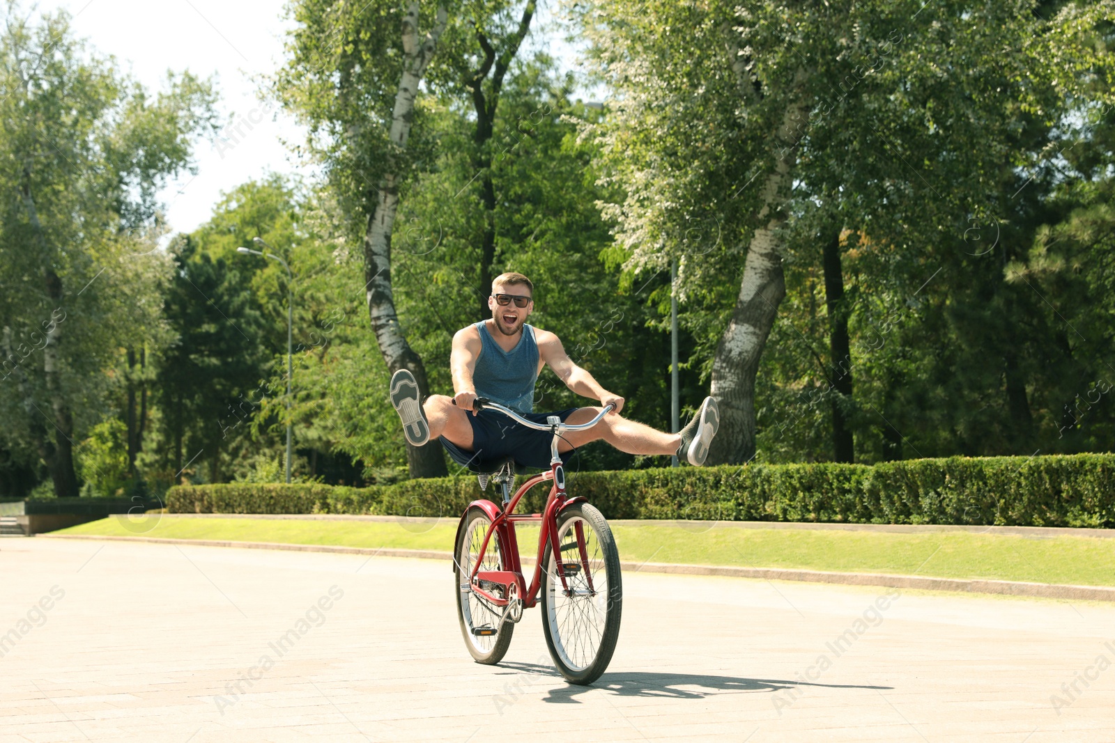 Photo of Attractive man riding bike outdoors on sunny day