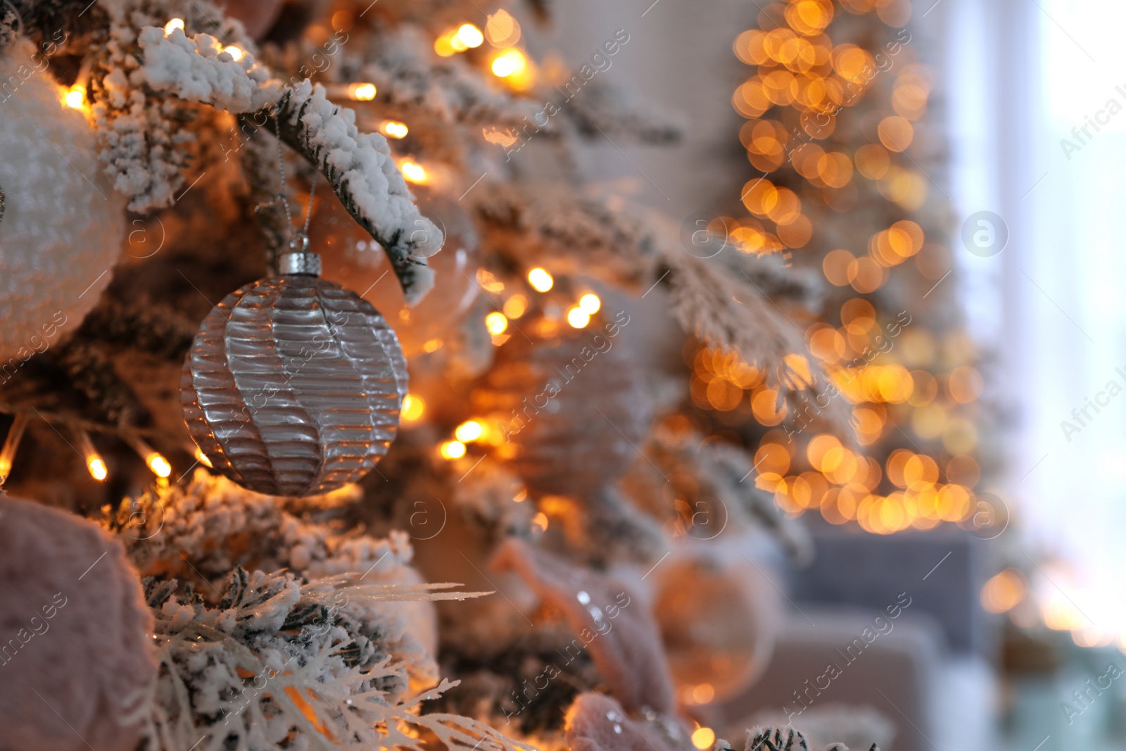 Photo of Christmas tree branch with balls indoors, closeup. Festive interior decoration