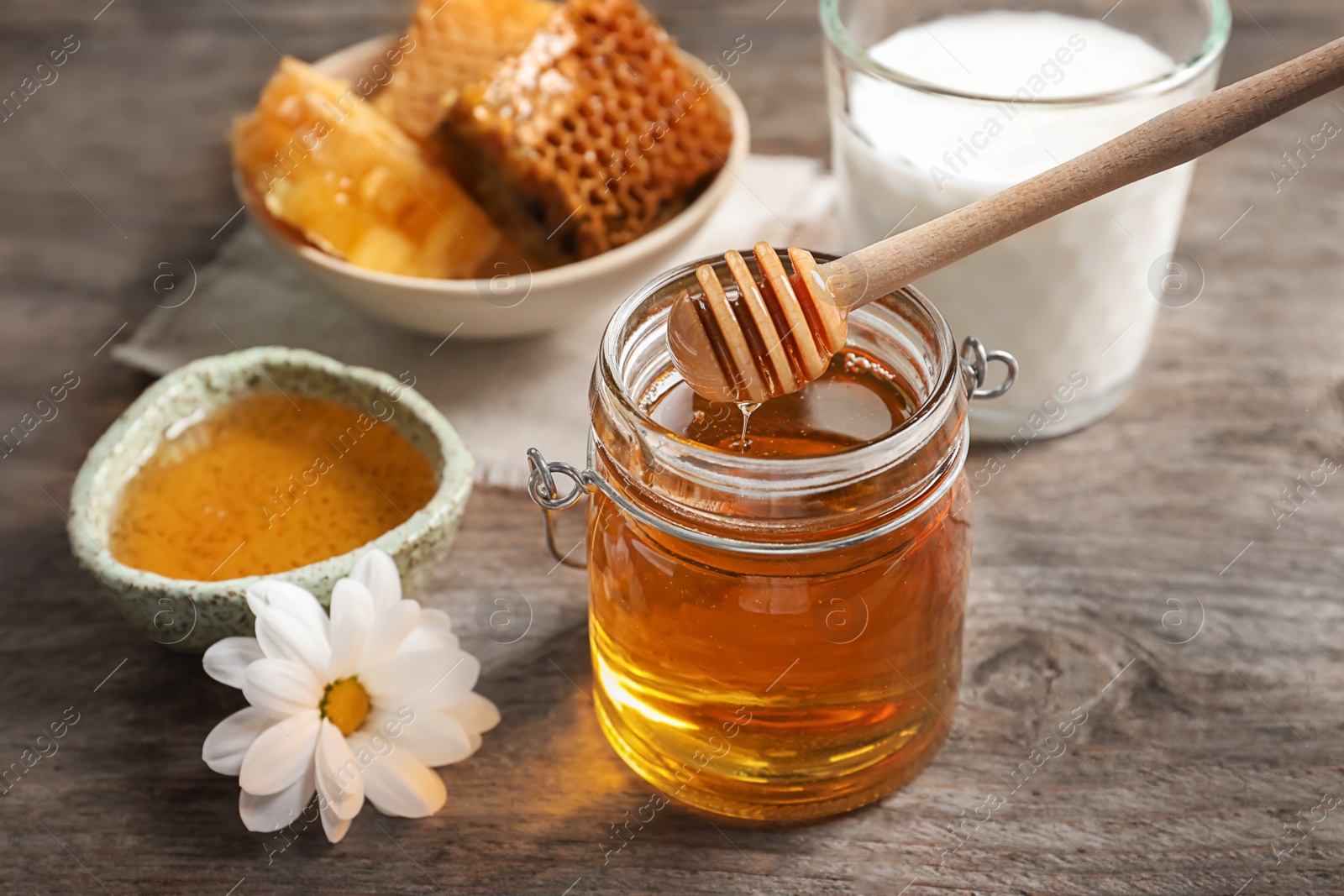 Photo of Beautiful composition with milk and honey on wooden background