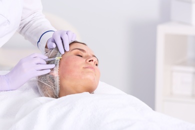 Woman undergoing face biorevitalization procedure in salon. Cosmetic treatment