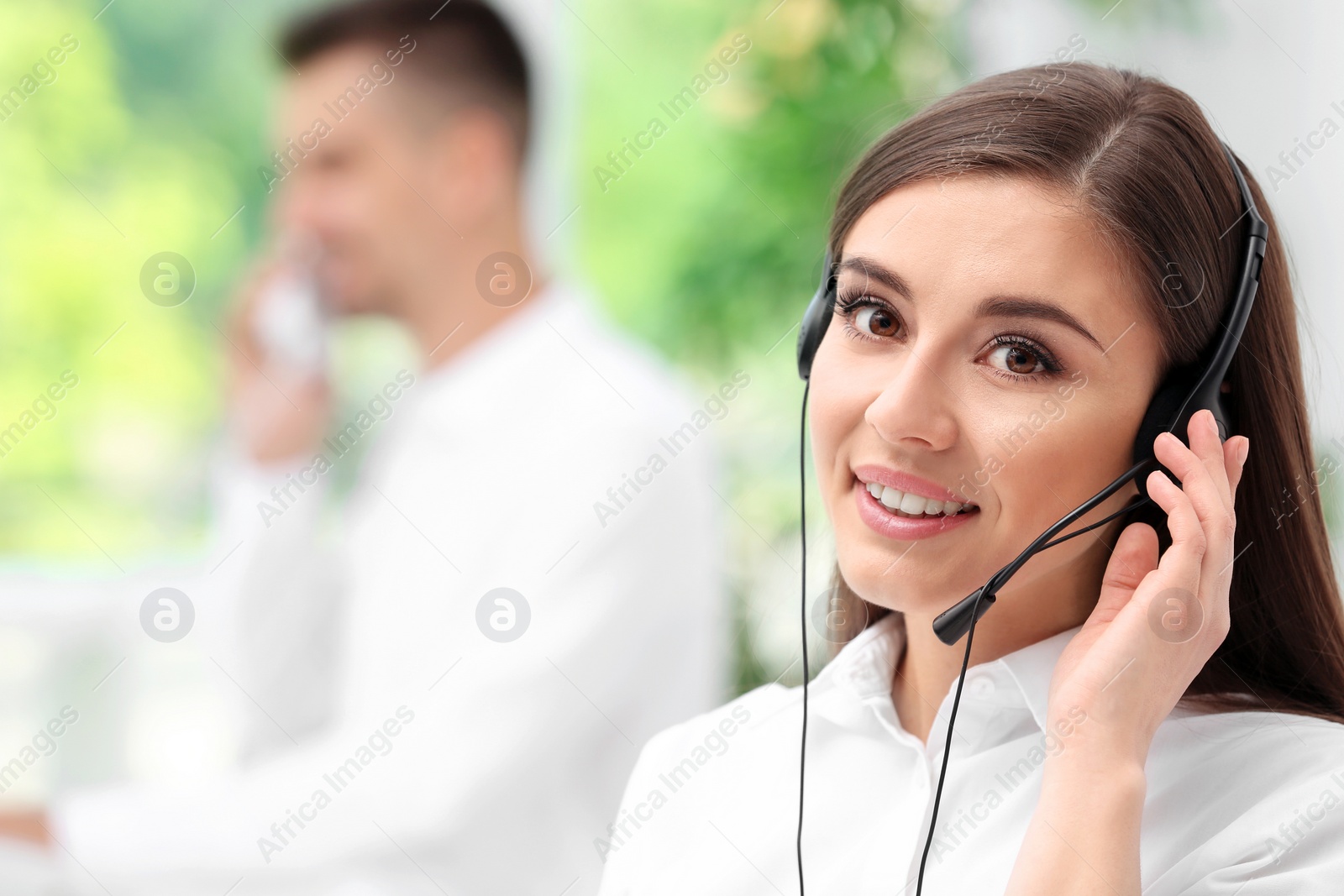 Photo of Young female receptionist with headset in office