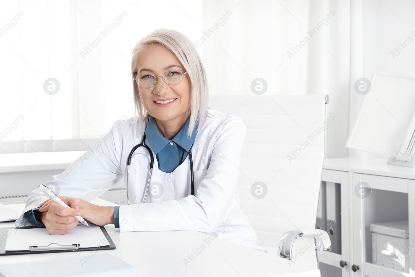 Photo of Portrait of mature female doctor in white coat at workplace