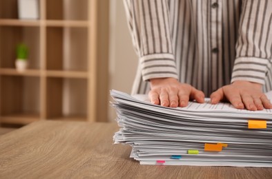 Woman stacking documents at wooden table indoors, closeup. Space for text