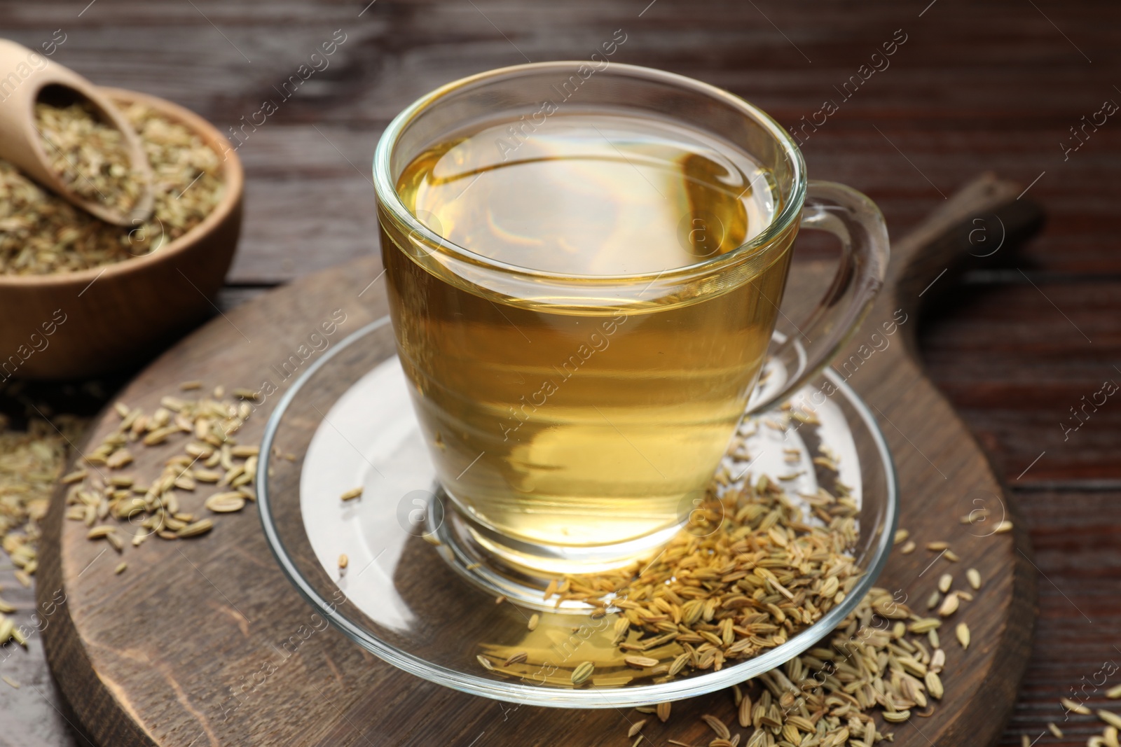 Photo of Aromatic fennel tea and seeds on wooden table, closeup