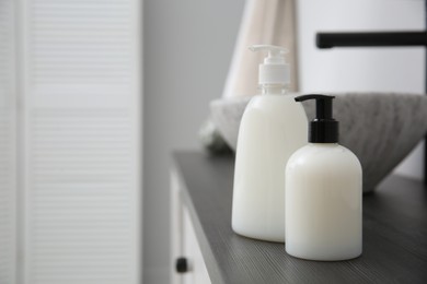 Dispensers of liquid soap on countertop in bathroom. Space for text