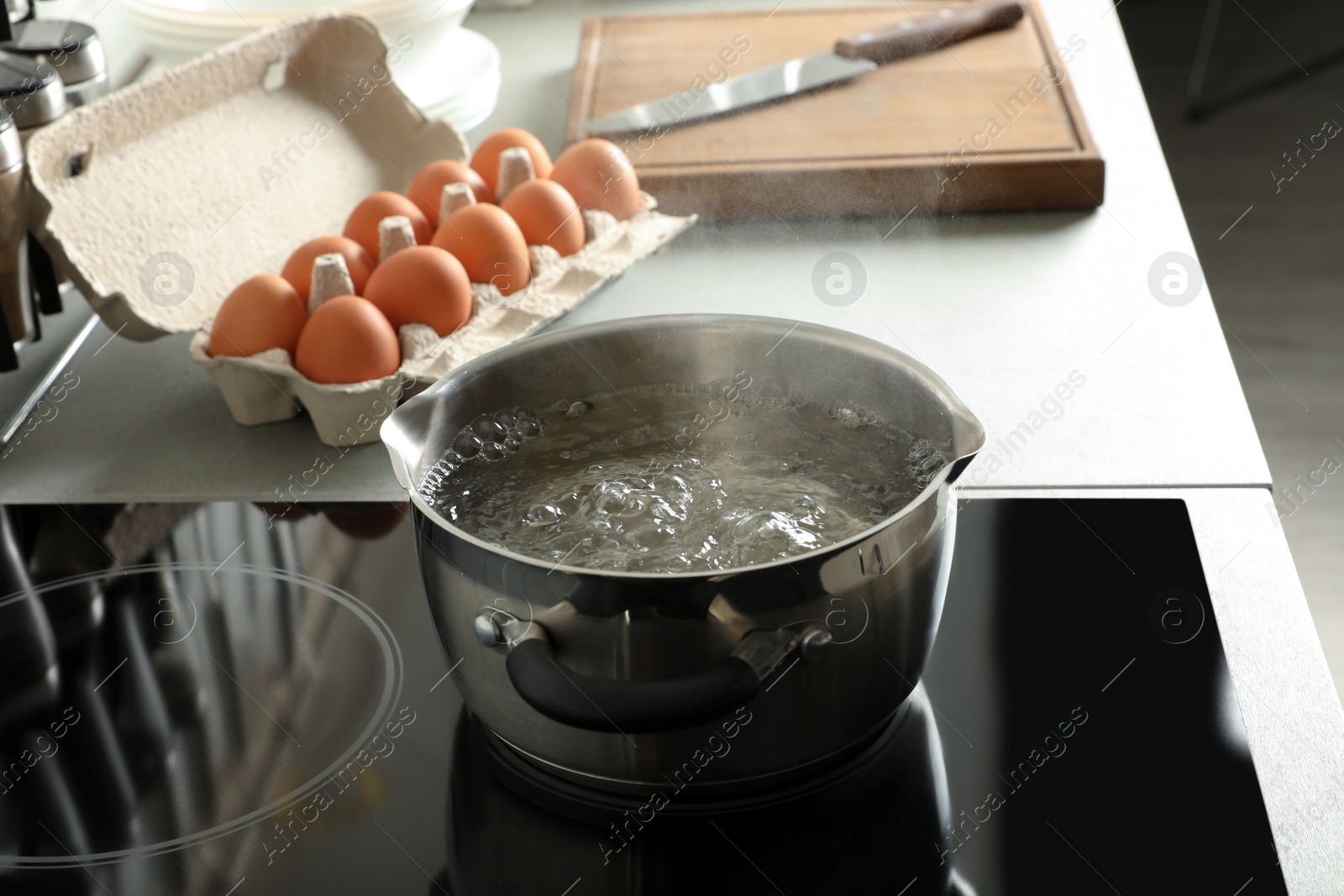 Photo of Pot with boiling water on electric stove in kitchen