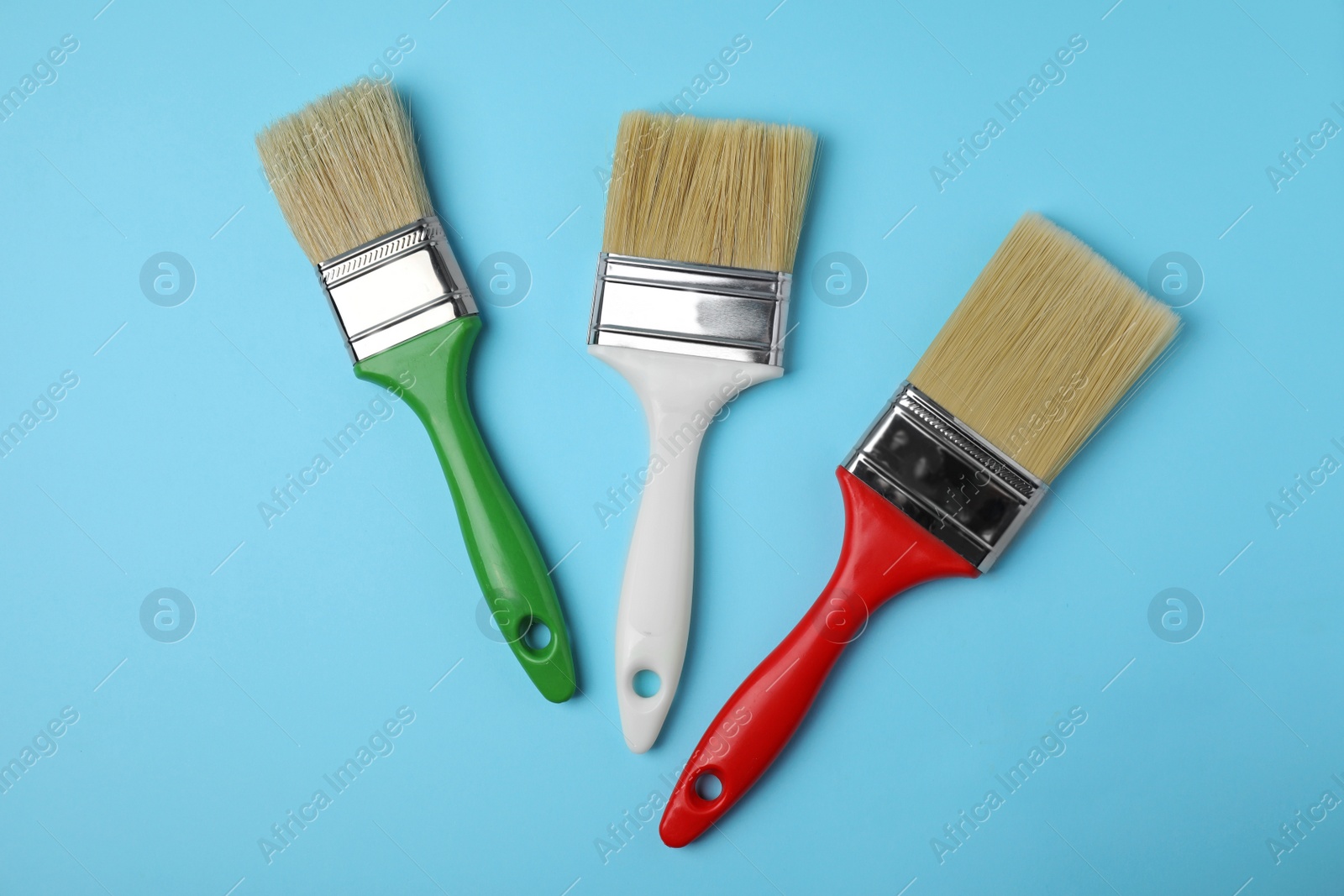 Photo of Paint brushes on color background, top view