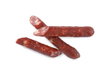 Photo of Thin dry smoked sausages isolated on white, top view