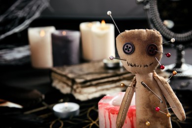Photo of Voodoo doll pierced with pins on table indoors, closeup. Space for text