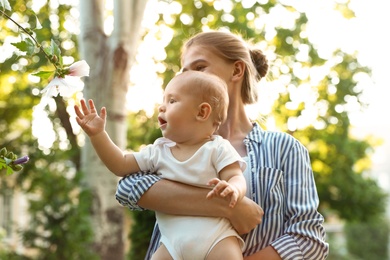 Photo of Teen nanny with cute baby in park on sunny day