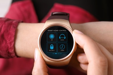 Image of Woman setting smart home control system via smartwatch, closeup. App interface with icons on display
