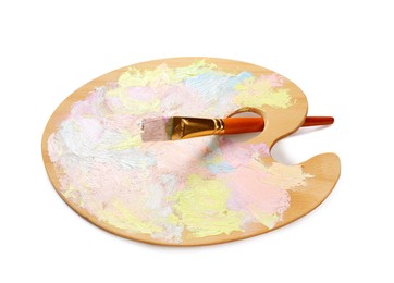 Photo of Wooden artist's palette with mixed pastel paints and brush isolated on white