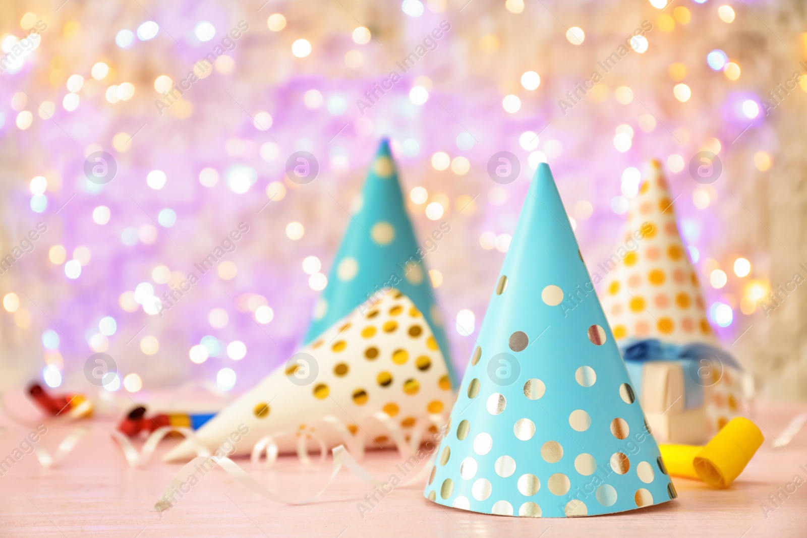 Photo of Birthday party caps on table against blurred lights