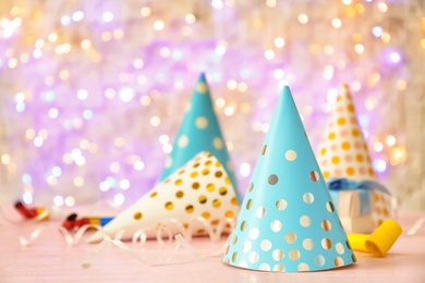 Photo of Birthday party caps on table against blurred lights