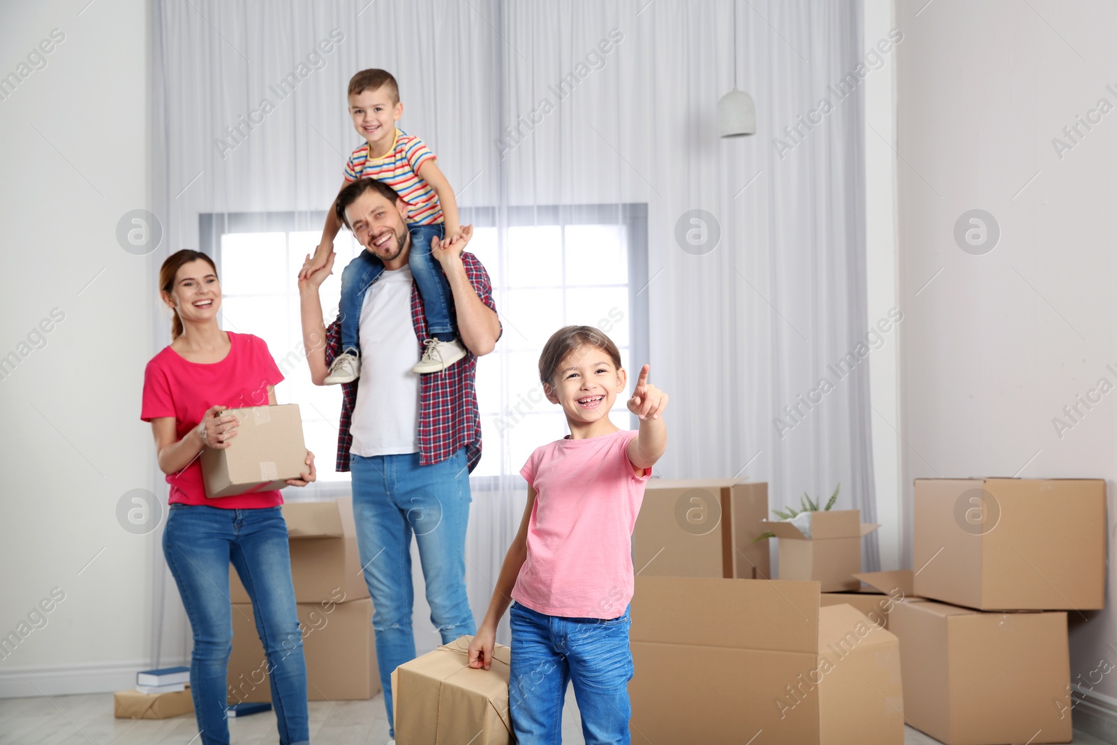 Photo of Happy family with moving boxes in their new house