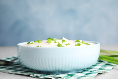 Photo of Fresh sour cream with onion on fabric