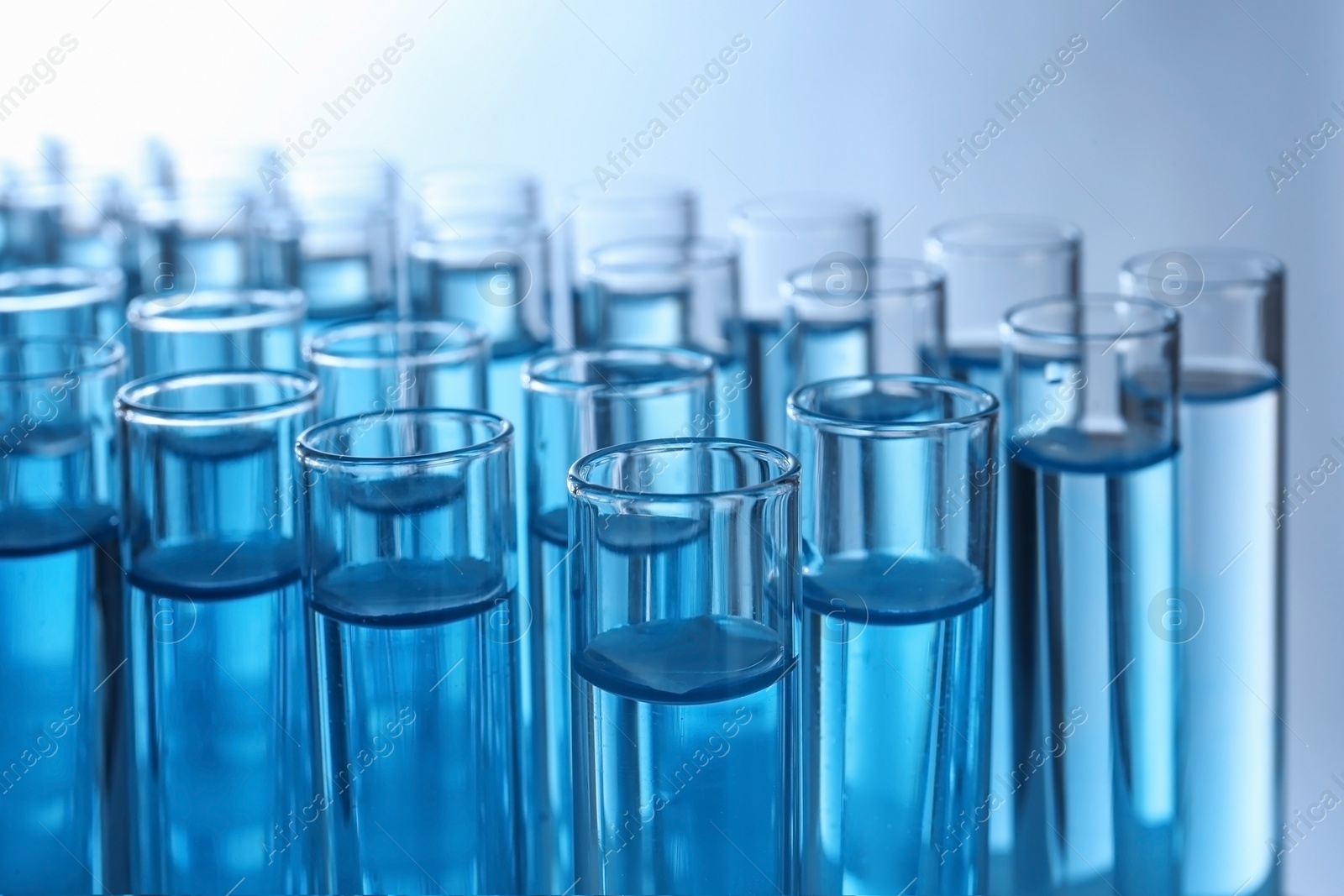 Photo of Test tubes with liquid against color background, closeup. Laboratory analysis