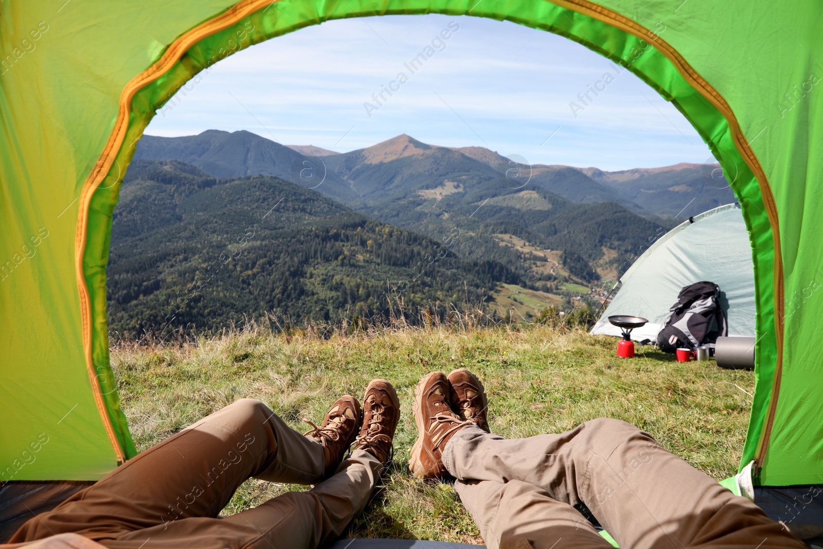 Photo of Couple resting inside of camping tent in mountains, closeup