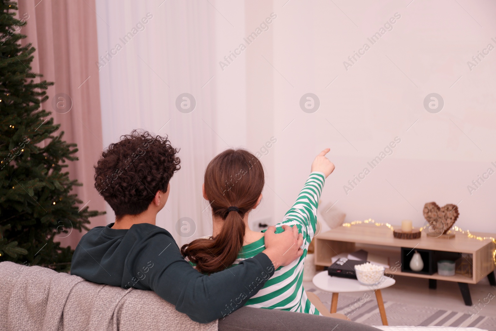 Photo of Couple watching movie via video projector at home