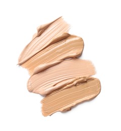 Samples of skin foundation on white background, top view