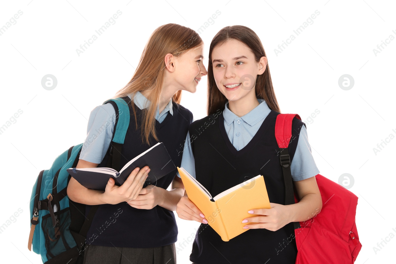 Photo of Portrait of teenage girls in school uniform with backpacks and books on white background