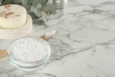Photo of Tooth powder, brush and soap on white marble table, space for text