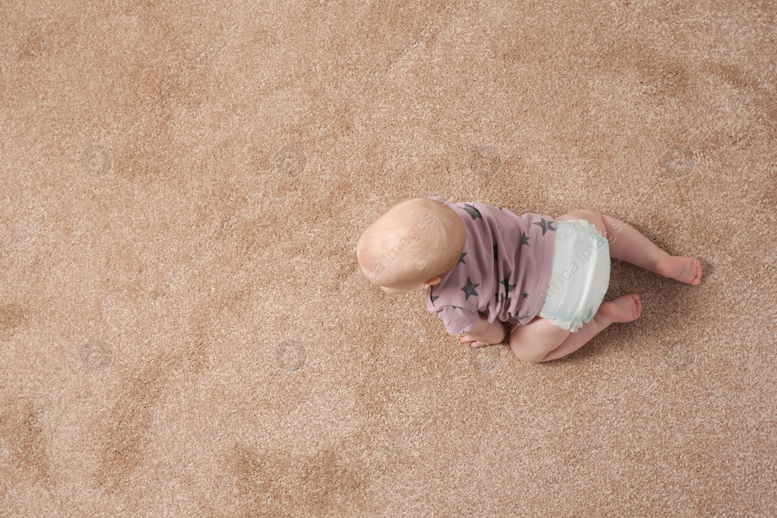 Photo of Cute little baby crawling on carpet indoors, top view with space for text