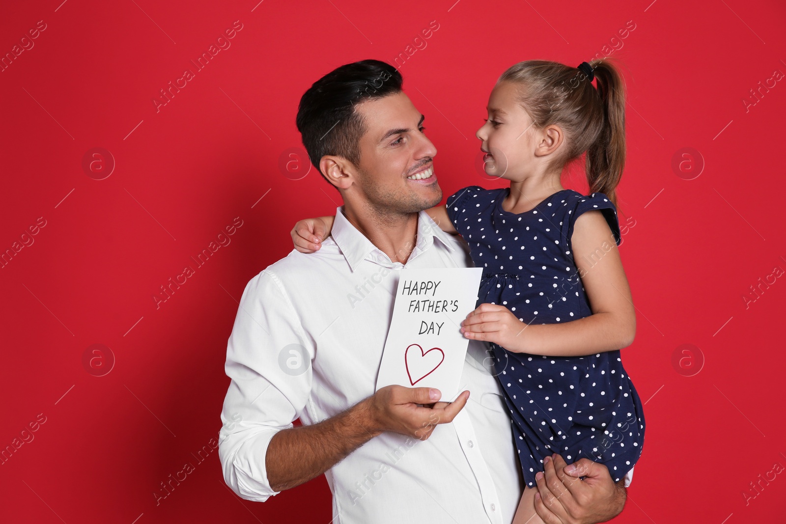 Photo of Little girl greeting her dad with Father's Day on red background
