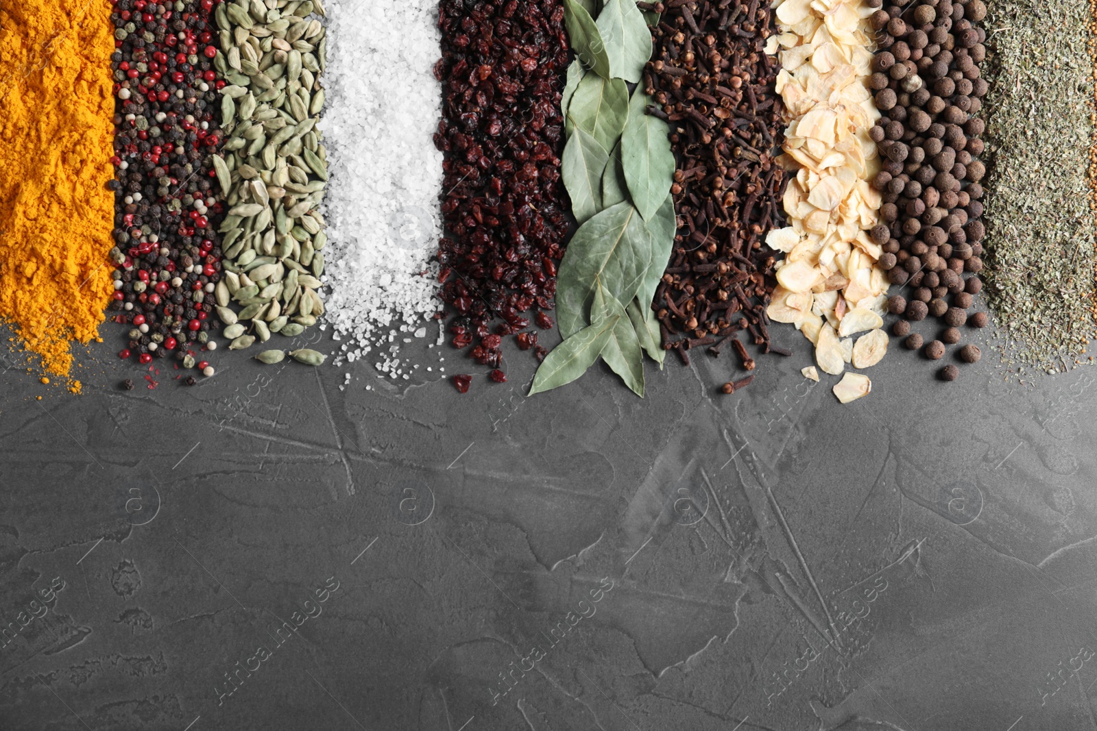 Photo of Different spices on grey background, top view. Space for text