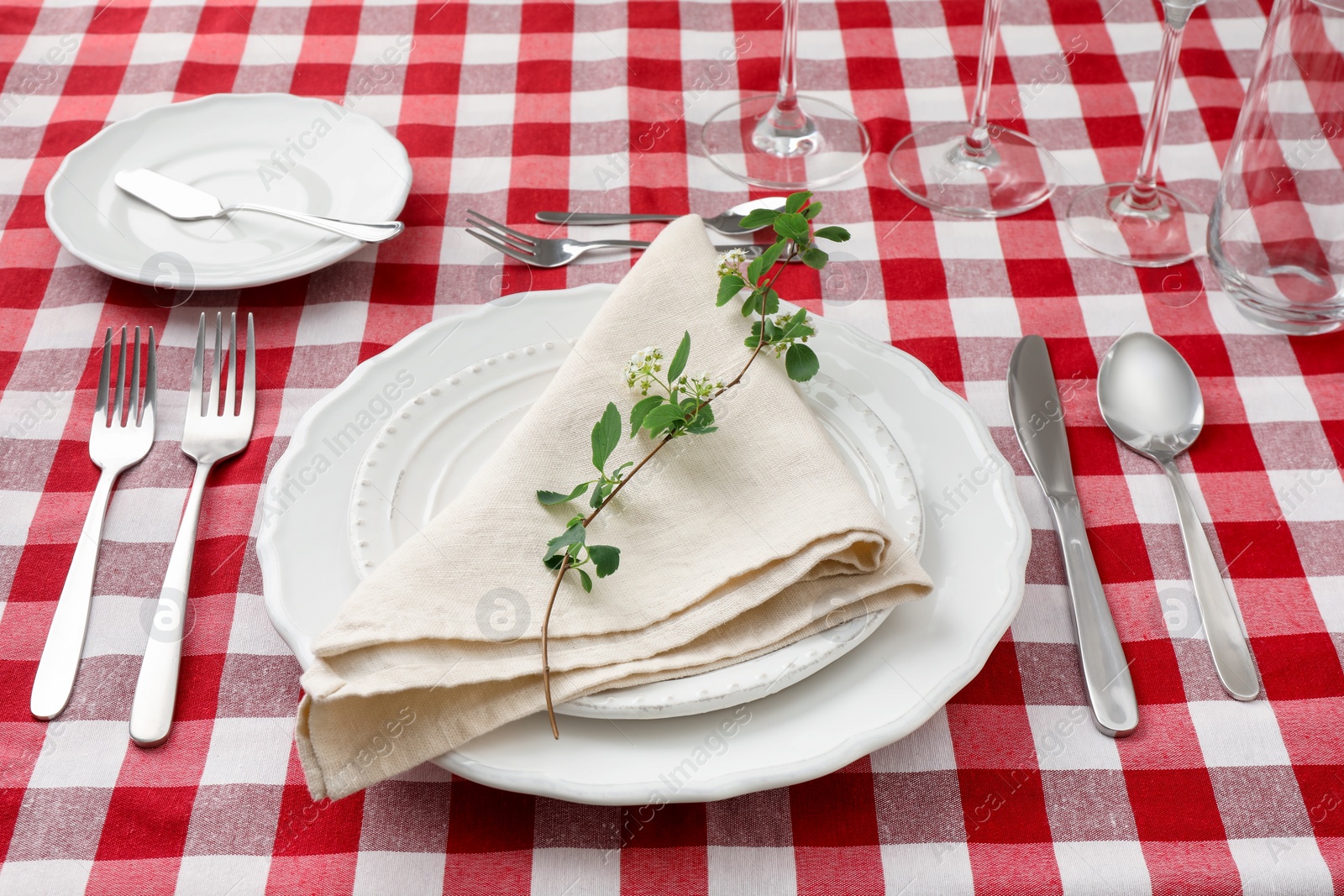 Photo of Stylish setting with cutlery, plates, napkin and floral decor on table