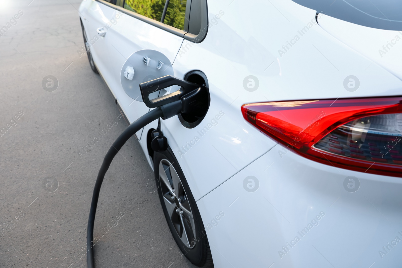 Photo of Charging modern electric car from station outdoors