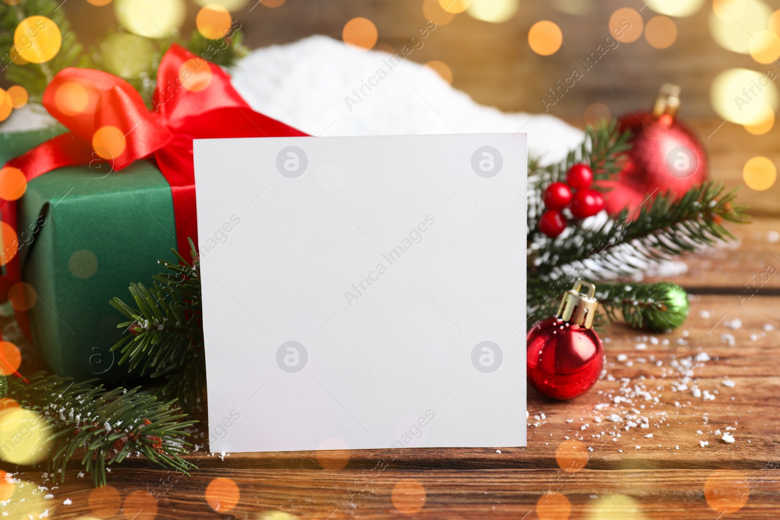 Photo of Blank Christmas card and festive decor on wooden table, closeup. Space for text