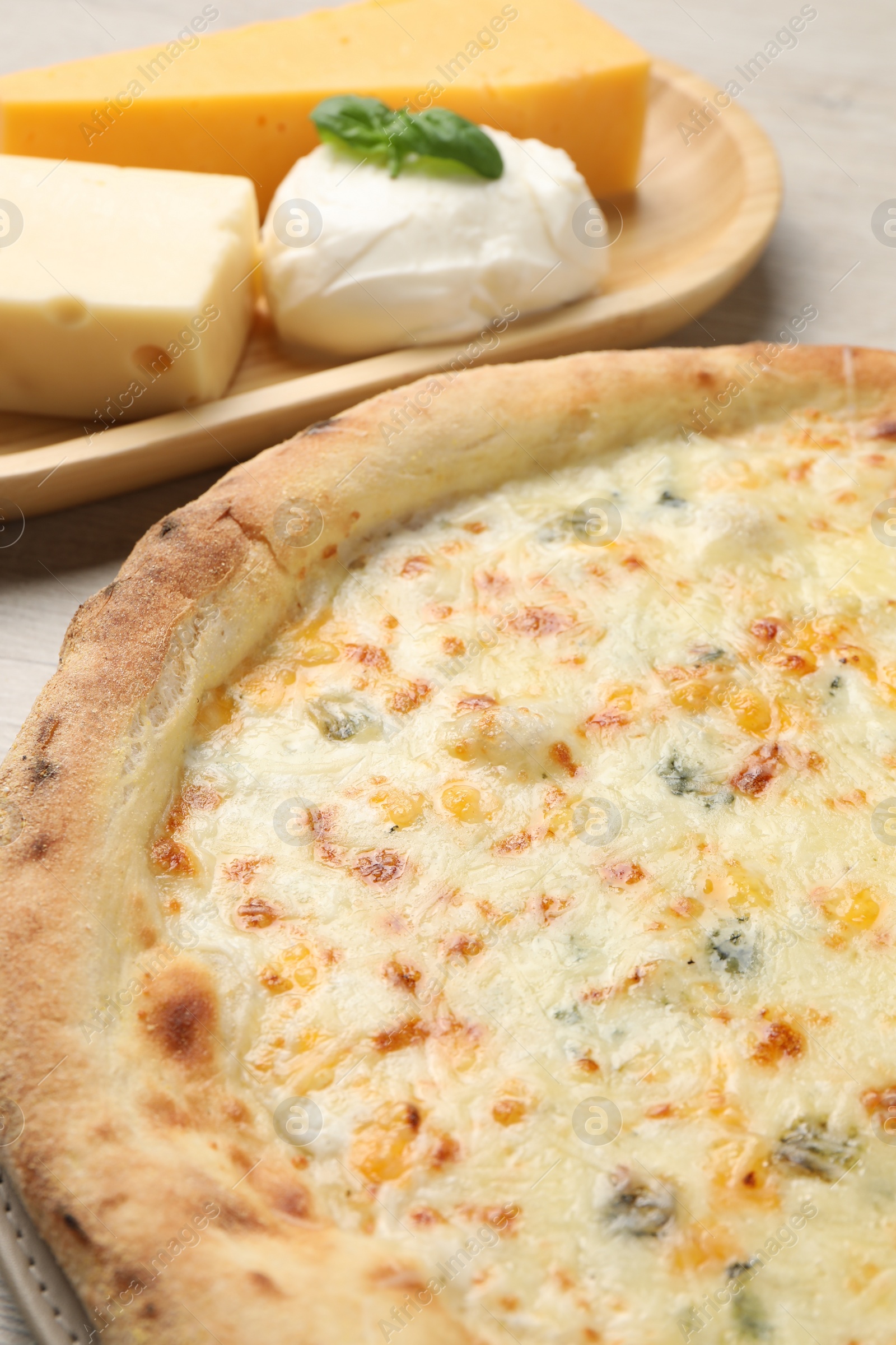 Photo of Delicious cheese pizza and different kinds of cheese on table, closeup