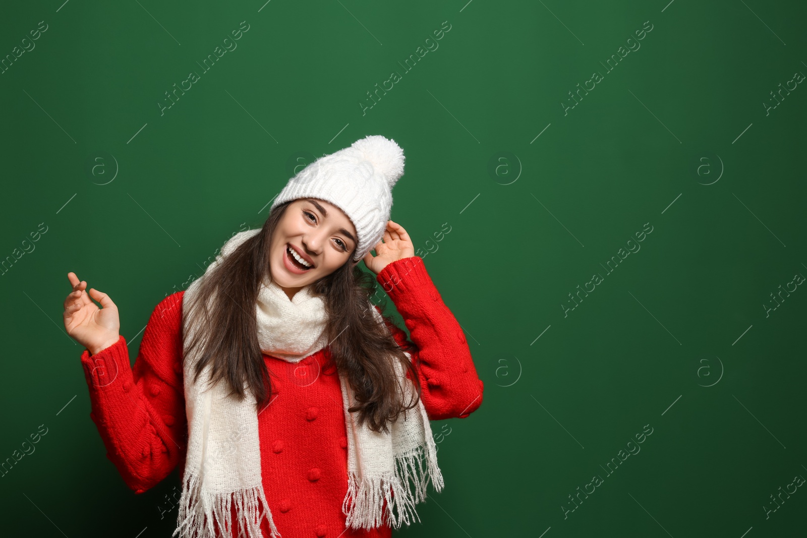 Photo of Young woman wearing warm clothes on color background, space for text. Winter season