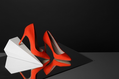 Pair of lady's shoes on table against black background, space for text