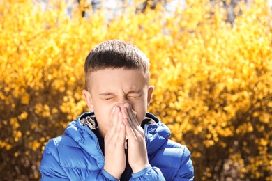 Little boy suffering from seasonal allergy outdoors on sunny day