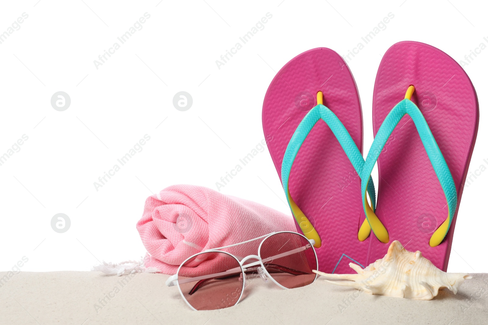 Photo of Different stylish beach accessories on sand against white background