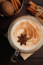 Delicious eggnog with spices on wooden table, flat lay