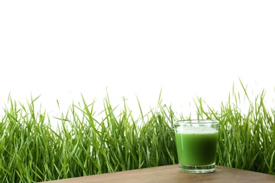 Photo of Glass of juice on table and fresh wheat grass against white background. Space for text