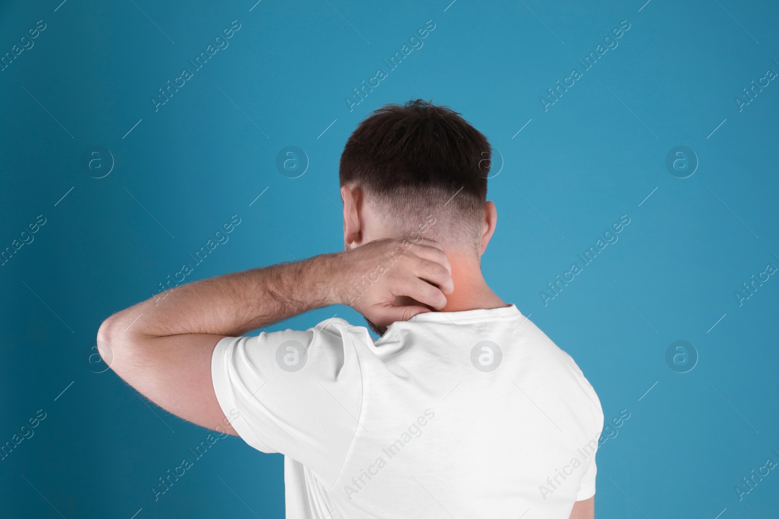 Photo of Man scratching neck on color background. Allergy symptoms