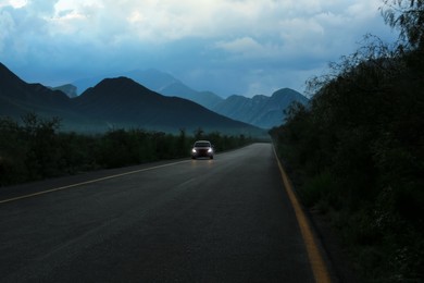 Photo of Beautiful view of car on asphalt highway in mountains. Road trip